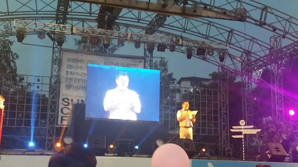 야외 공연 무대에서 진행하는 MC와 대형 스크린
