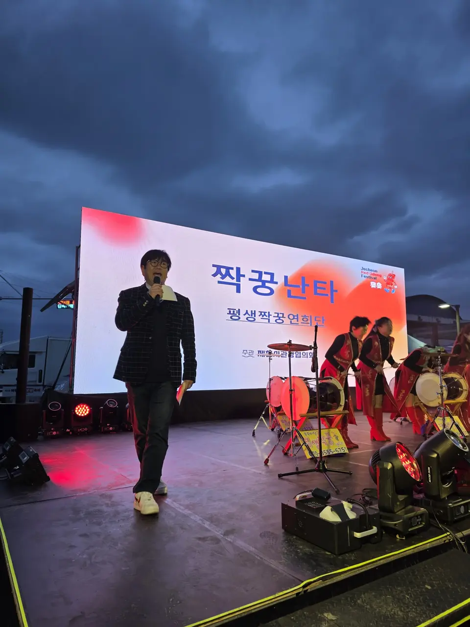 야외 무대 위에서 홀로 마이크를 잡고 진행하는 MC