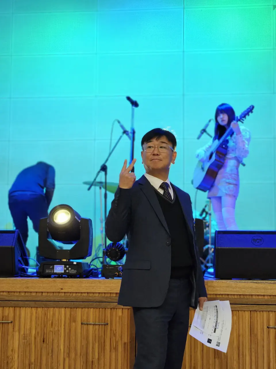 밴드 공연이 있는 무대 앞에 서 있는 MC