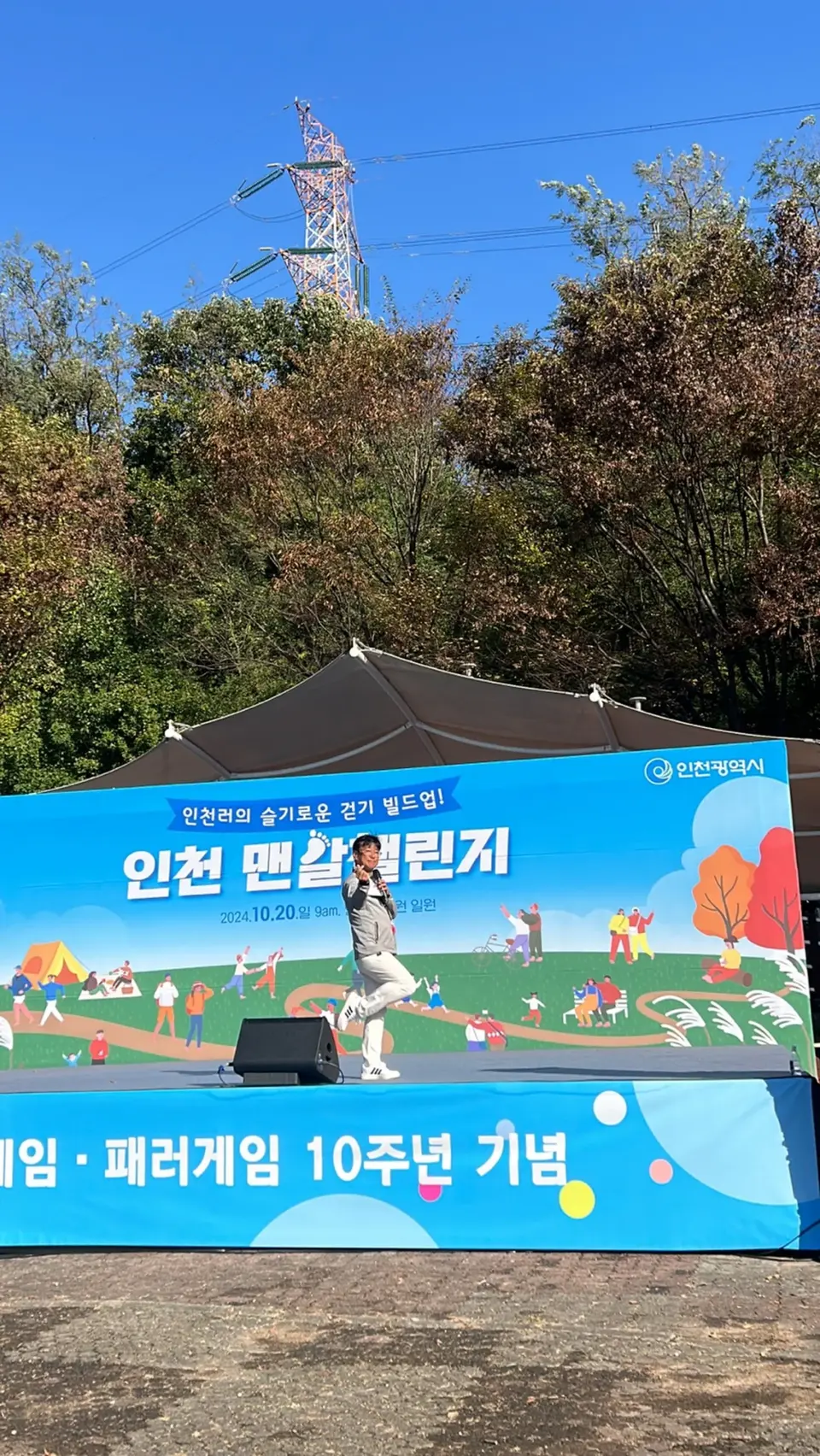 야외 행사 무대와 현수막이 보이는 세로 구도 장면