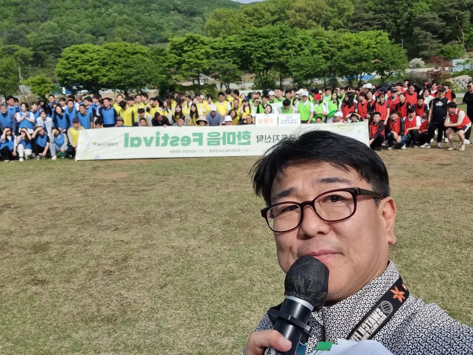 단체 참가자들 앞에서 마이크를 들고 찍은 MC 신용주의 현장 셀피