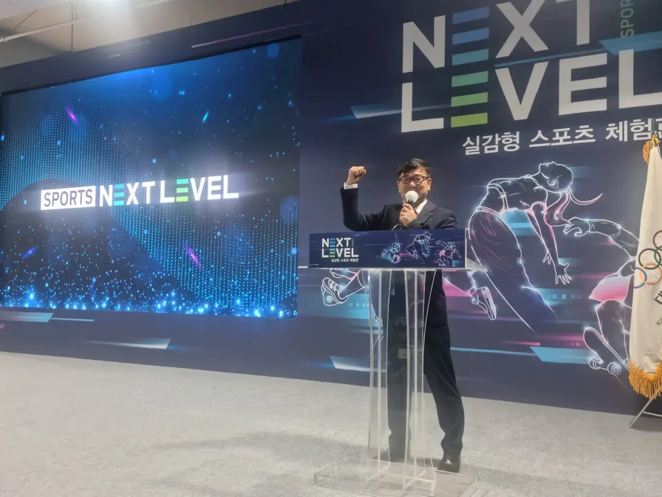 투명 연단에서 주먹을 들고 진행하는 MC와 LED 스크린